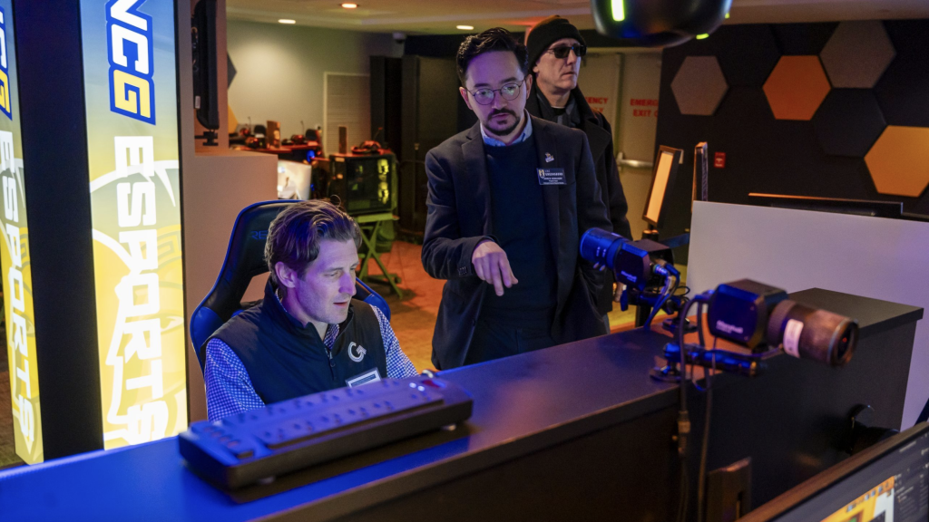 Dr. John Borchert speaks to a man in the esports arena